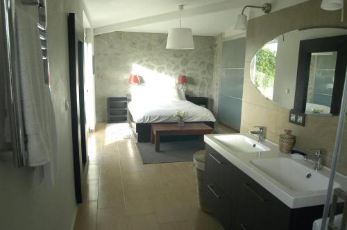 y baño con cama, lavabo y espejo. en Los Olivos Villa, en Sanlúcar de Barrameda
