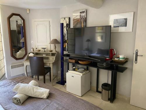 a bedroom with a flat screen tv and a bed at La Borie en Provence in Gordes