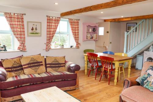 a living room with a couch and a table at Cob Cottage in Tomhaggard