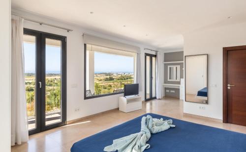 a bedroom with a blue rug and large windows at Colonies in Ses Salines