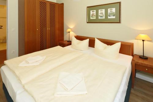 ein großes weißes Bett mit zwei weißen Handtüchern darauf in der Unterkunft Villa Aegir Villa Aegir 122 in Heringsdorf