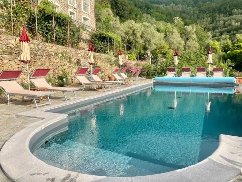 una piscina con tumbonas y sombrillas en Villa Barca - Luxury Vacation Rentals - Wellness & Pool, en Casanova Lerrore