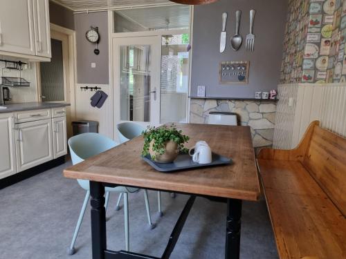 a kitchen with a wooden table with a plant on it at Het Voorhuis boerderij Hoeve Vrede Best in Weesp