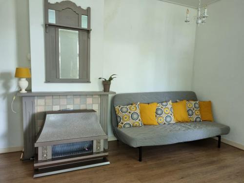 a living room with a couch and a mirror at Het Voorhuis boerderij Hoeve Vrede Best in Weesp