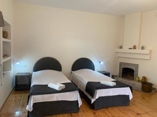 2 camas en una habitación con chimenea en Hotel Lemi, en Mestia
