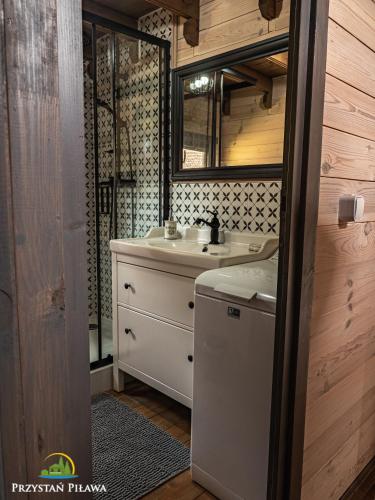 a bathroom with a sink and a washing machine at Przystań Piława in Borne Sulinowo