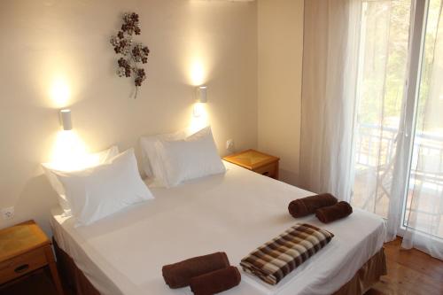 a bedroom with a white bed with two towels on it at K Farm House in Kalavárda