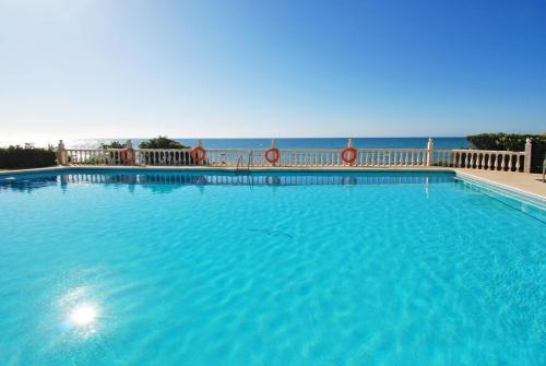 a large swimming pool with the ocean in the background at Casa Linda La Lubina, front the beach La Lucera, Riviera del Sol in Sitio de Calahonda