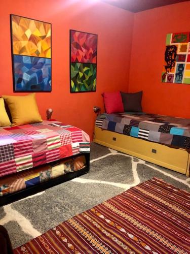 two beds in a room with orange walls at Cardenha do Douro in Mesão Frio