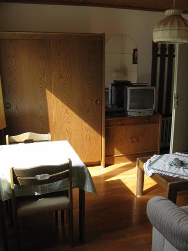 a living room with a table and a tv at Gasthof Laggner in Steindorf am Ossiacher See