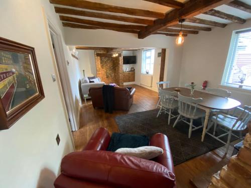 a living room with a couch and a table at Stoop Cottage - in the heart of Quorn in Quorndon