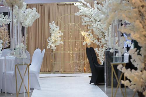 a wedding hall with white flowers and black chairs at Landhotel zum kühlengrund & soultans paradise in Brensbach