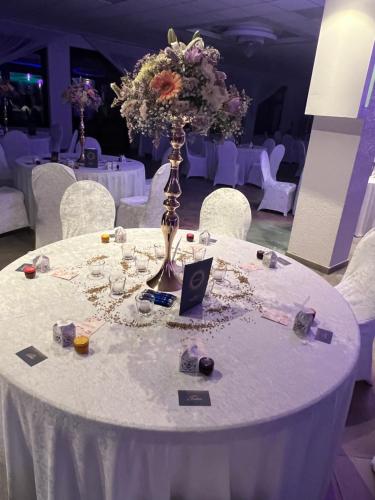 a white table with a vase with flowers on it at Landhotel zum kühlengrund & soultans paradise in Brensbach