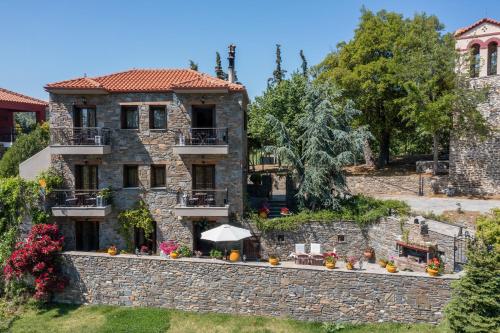 a large stone house with a stone wall at Chorostasi Guest House in Parthenonas