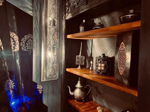 a room with wooden shelves with vases and a tea pot at Chambres d'hôtes - Le Nador in Meurchin
