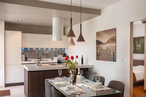a kitchen and dining room with a table with red roses at Alba Residence in Split