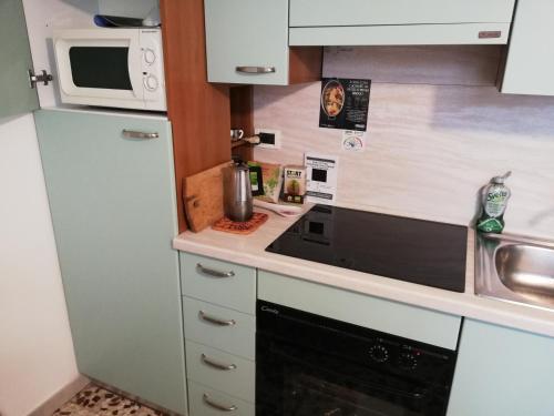 eine kleine Küche mit einem Herd und einer Mikrowelle in der Unterkunft Al mare con vista codice CITRA 009049-LT-0787 in Pietra Ligure