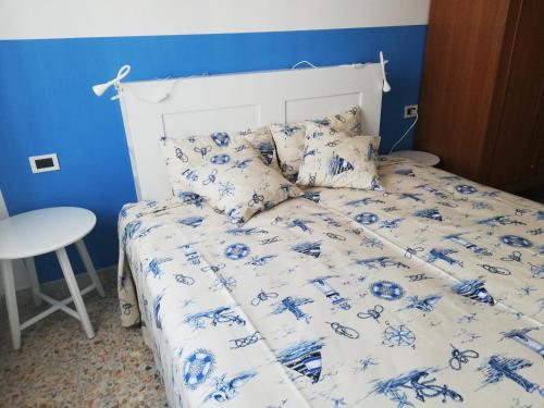 a bed with a blue and white comforter and pillows at Al mare con vista codice CITRA 009049-LT-0787 in Pietra Ligure