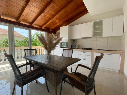 een keuken met een houten tafel en stoelen in een kamer bij Apartments Iva in Pakoštane