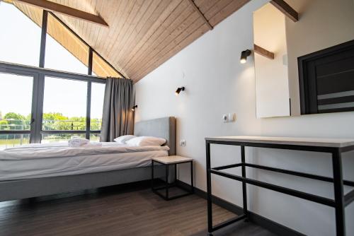 a bedroom with a bed and a large window at Shepilska Relax Complex in Dovholuka
