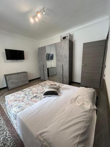 a bedroom with a large bed with a tv on the wall at Grey house in Genoa