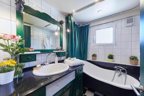 a bathroom with two sinks and a tub and a mirror at Villa Dennis in Vrahati