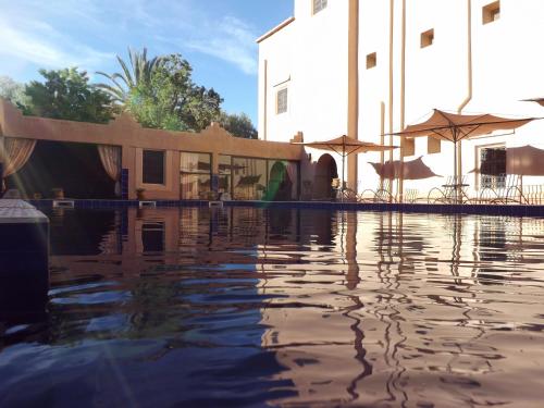 a pool of water in front of a building at Kasbah Ait ben Damiette in Skoura