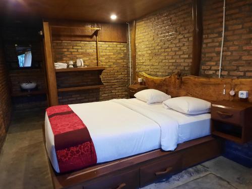 a bedroom with a large bed with a wooden headboard at The Boat Homestay and Spa in Balige