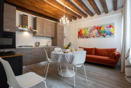 kuchnia i salon ze stołem i krzesłami w obiekcie Ve.N.I.Ce. Cera Ca' De La Mandola w Wenecji