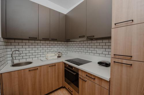 a kitchen with wooden cabinets and a sink at Trsteno Beach Apartments in Budva
