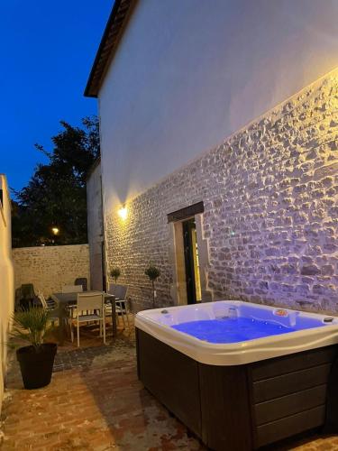 un bain à remous dans une cour avec patio dans l'établissement L'ATELIER DU VIEUX BOIS Spa, à Bayeux