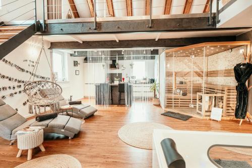 a living room filled with furniture on top of a wooden floor at Luxusloft Timeout with private Spa in Ralingen