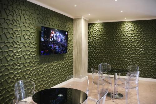 jadalnia ze stołem i telewizorem na ścianie w obiekcie Hotel Donatello w mieście Modena