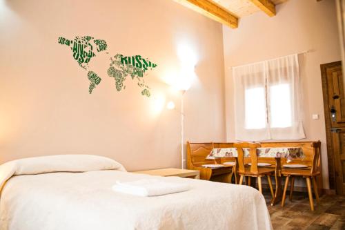 Un dormitorio con una cama y una mesa y un mapa mundial en la pared en Apartamentos turísticos LAS CARBALLEDAS, en Rabanal del Camino