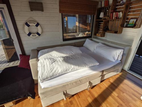 una cama en la parte trasera de una casa pequeña en Großes gemütliches Hausboot in Berlin en Berlín