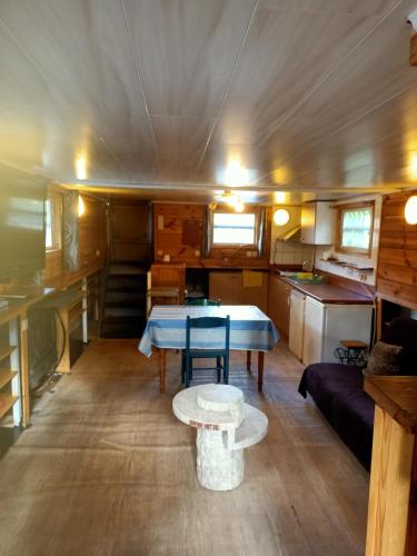 a living room with a table and a couch at le bateau sur lac privé de 2 hectares poissonneux au milieu des bois in Florennes