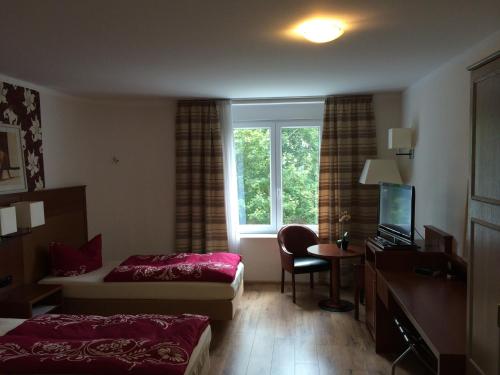 Una habitación de hotel con dos camas y una ventana. en Heiterer Blick am Malerweg Pirna, en Pirna