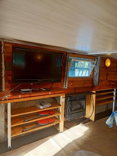 a tv on a wooden desk with a tvictericter at le bateau sur lac privé de 2 hectares poissonneux au milieu des bois in Florennes