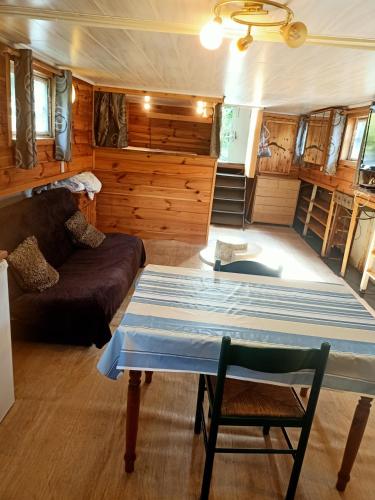 a living room with a couch and a table at le bateau sur lac privé de 2 hectares poissonneux au milieu des bois in Florennes