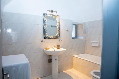 a bathroom with a sink and a toilet and a mirror at Mylos villa Mani in Pírgos