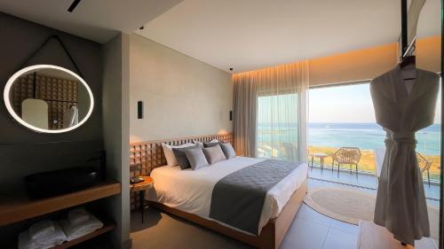 a bedroom with a large bed and a large window at Cavo Zoe Seaside Hotel in Protaras