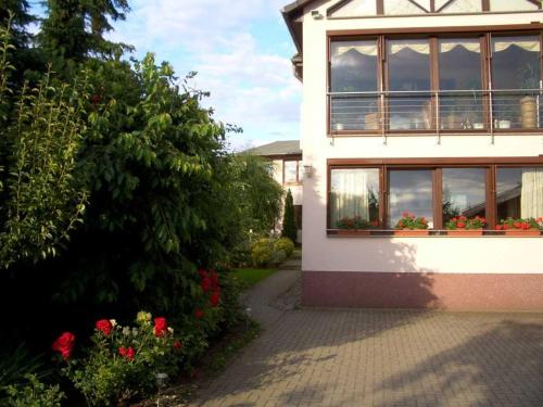 ein Haus mit Fenstern und Blumen davor in der Unterkunft Ferienwohnung "Juli" Objekt ID 13432 in Waren (Müritz)