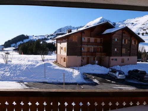 a house with a car parked in a parking lot with snow at Pic Chaussy A2 in Les Mosses
