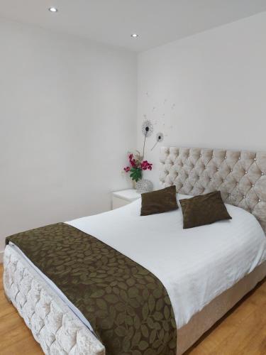 a bedroom with a large bed with a tufted headboard at Lux Apartment in Gatwick in Crawley