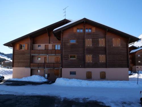 a large wooden building with snow in front of it at Pic Chaussy A2 in Les Mosses