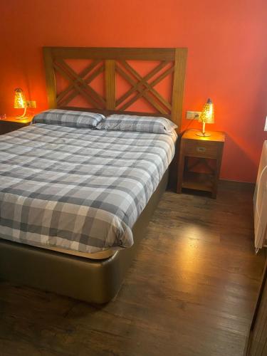 1 dormitorio con 1 cama con pared de color naranja en Precioso apartamento en Espot en Espot