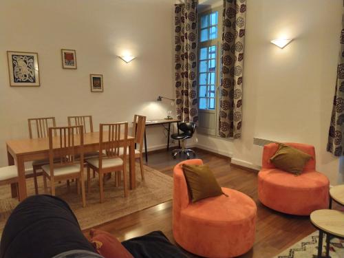 un salon avec une table et des chaises dans l'établissement Amatxi Etxea Au cœur du centre historique, à Bayonne