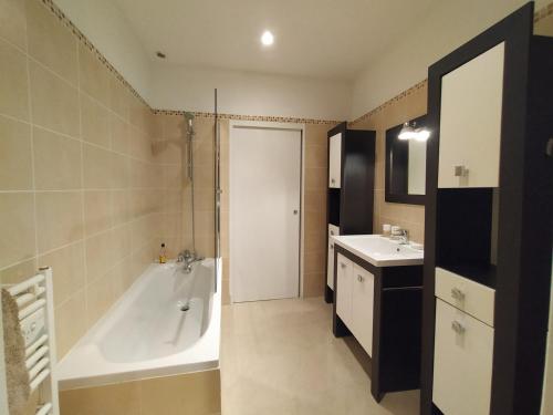 une salle de bain avec une baignoire et un lavabo dans l'établissement Amatxi Etxea Au cœur du centre historique, à Bayonne