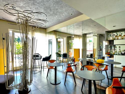 a restaurant with tables and chairs in a room at Tobago in Garda