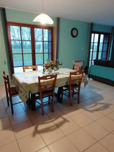 - une salle à manger avec une table, des chaises, une table et des chaises dans l'établissement LA VALLEE MARIAUX, à Bossus-lès-Rumigny